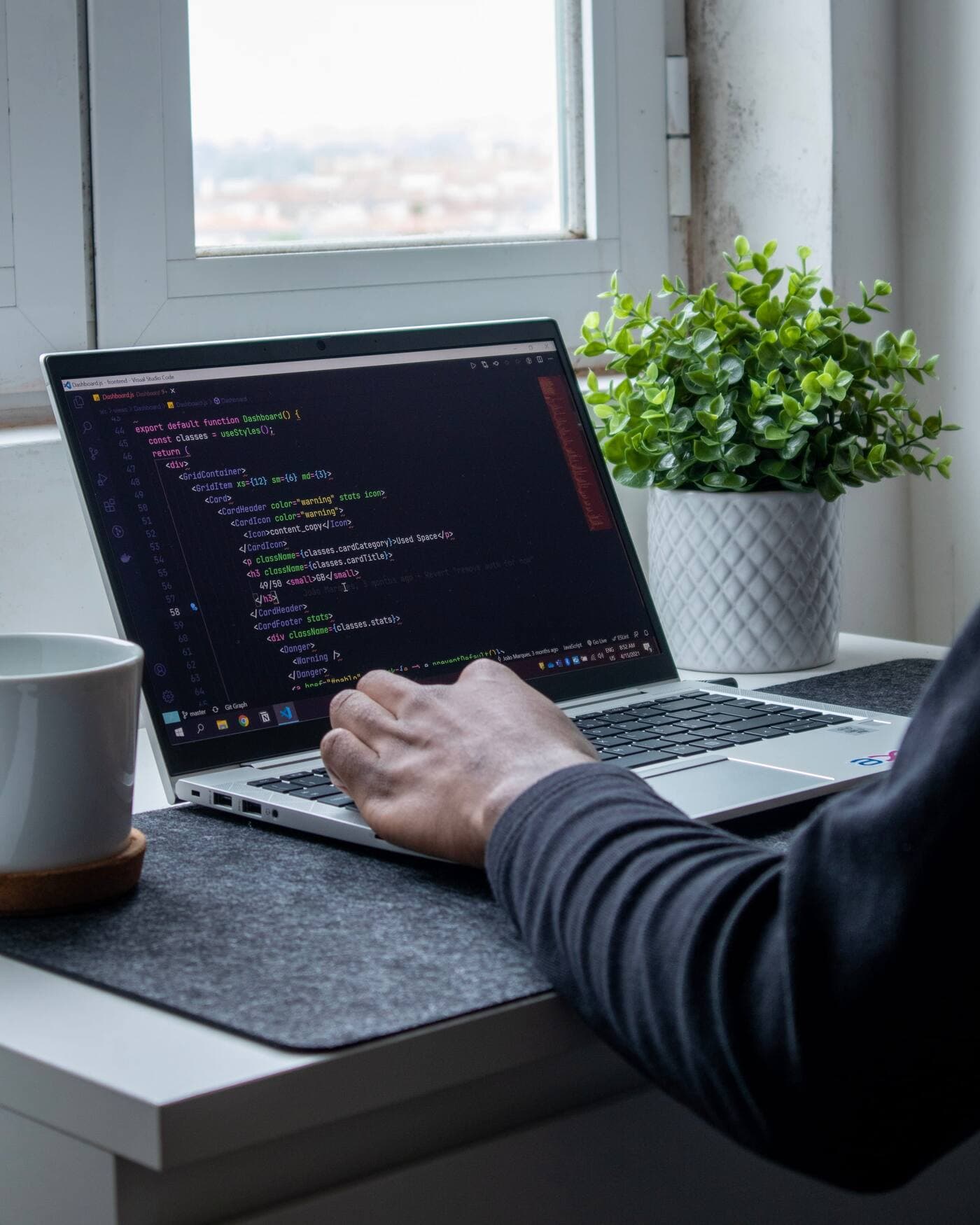 Developer writing code on a laptop
